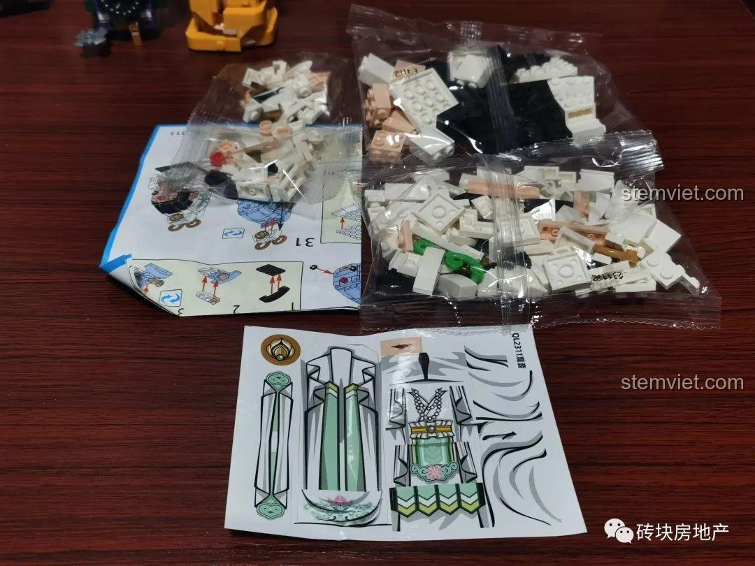 Các túi mảnh ghép, sách hướng dẫn và miếng dán của bộ lắp ghép Quan Âm Bồ Tát Zhegao QL2311.