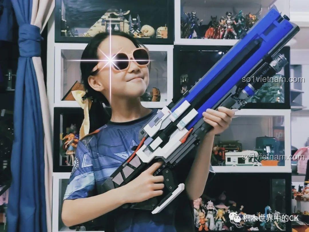 Một bé trai đeo kính râm đang cầm và tạo dáng ngầu với mô hình súng JIESTAR 58023 đã hoàn thiện.