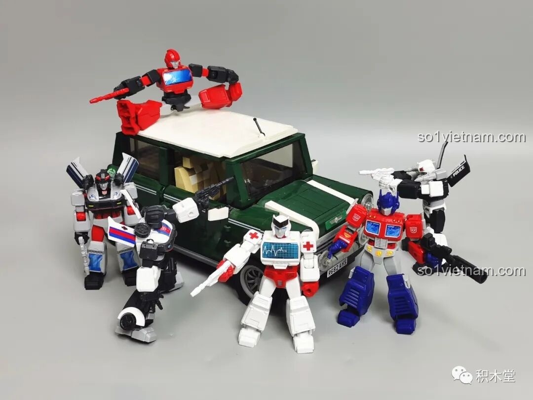 Các figure Autobot từ bộ BLOKEES 71100 tạo dáng bên cạnh một mô hình xe hơi lắp ráp, cho thấy sự tương tác thú vị.