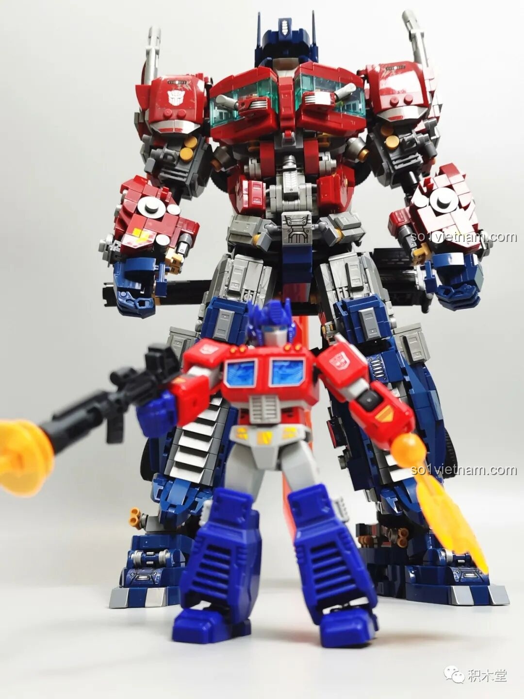 Một góc nhìn khác về hai phiên bản Optimus Prime, cho thấy sự khác biệt trong thiết kế và tỷ lệ giữa hai mô hình.