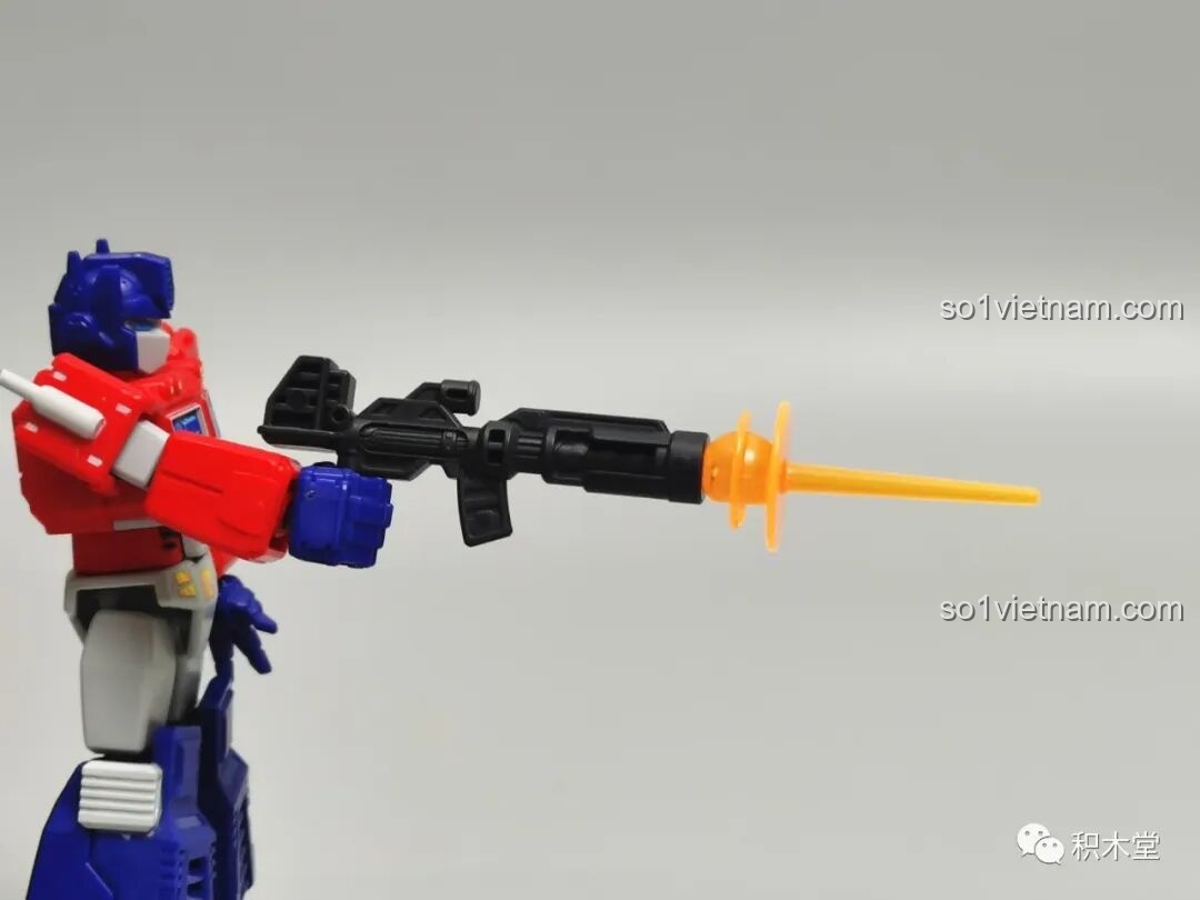 Figure Optimus Prime BLOKEES 71100 với hiệu ứng đạn bắn màu cam đi kèm, tạo ra một cảnh hành động sống động.