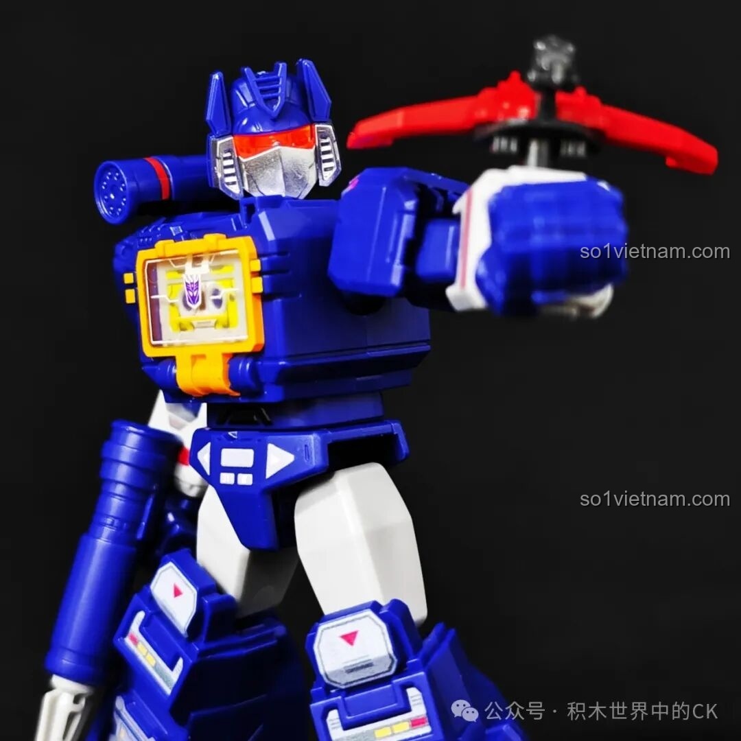 Figure Soundwave Blokees 71122 tạo dáng chiến đấu với Laserbeak trên tay trong điều kiện ánh sáng tối.