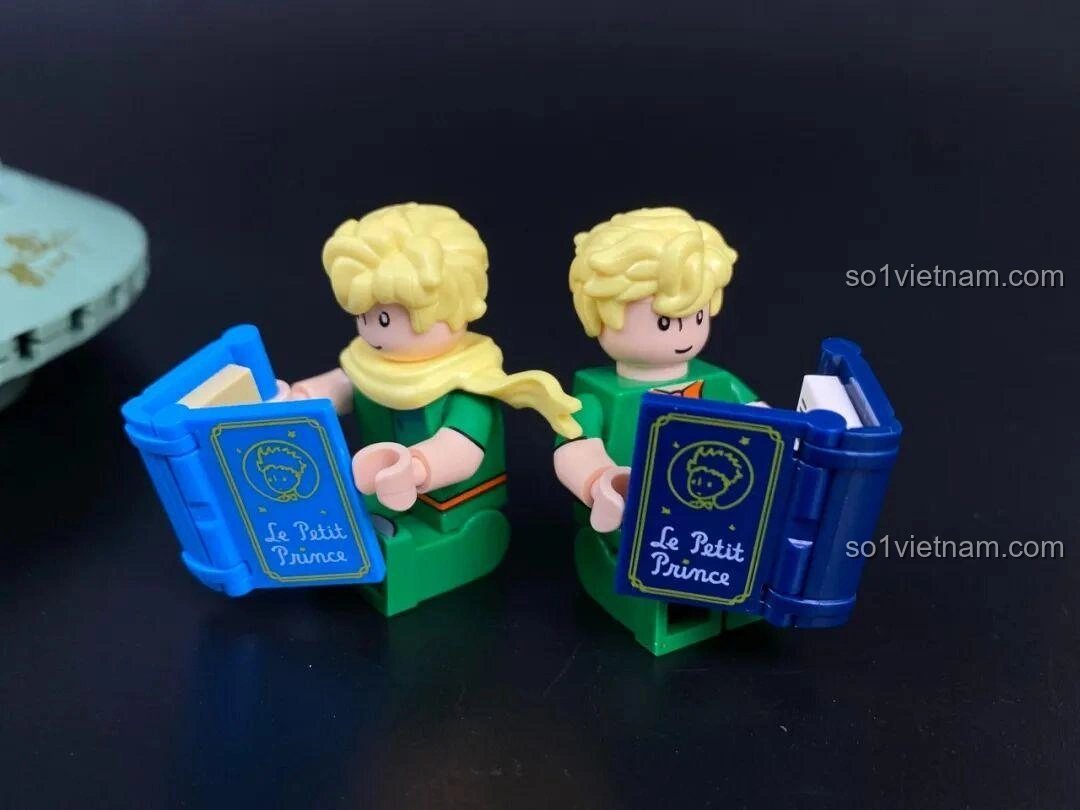 Hai mô hình Hoàng tử bé mini trong bộ Đồng Hồ Cát 86301, một có khăn quàng, một không.