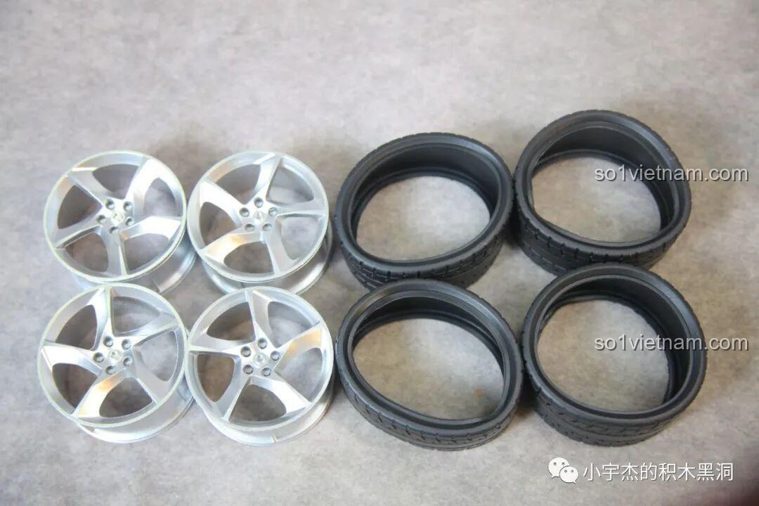 Bộ bốn vành xe sơn bạc và bốn lốp cao su của bộ xếp hình Biểu tượng xe thể thao Ferrari F40 X001 trước khi lắp ráp.