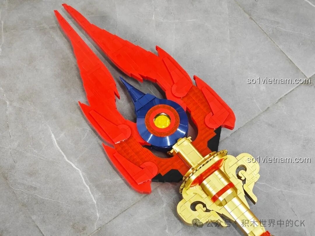 Tổng thể phần đầu của JIESTAR 58112 Trượng Hộ Ma Genshin Impact, nổi bật với màu đỏ và vàng đồng, chi tiết sắc sảo.