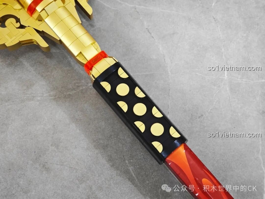 Họa tiết chấm tròn vàng trên nền đen ở phần thân JIESTAR 58112 Trượng Hộ Ma Genshin Impact, tạo điểm nhấn độc đáo.