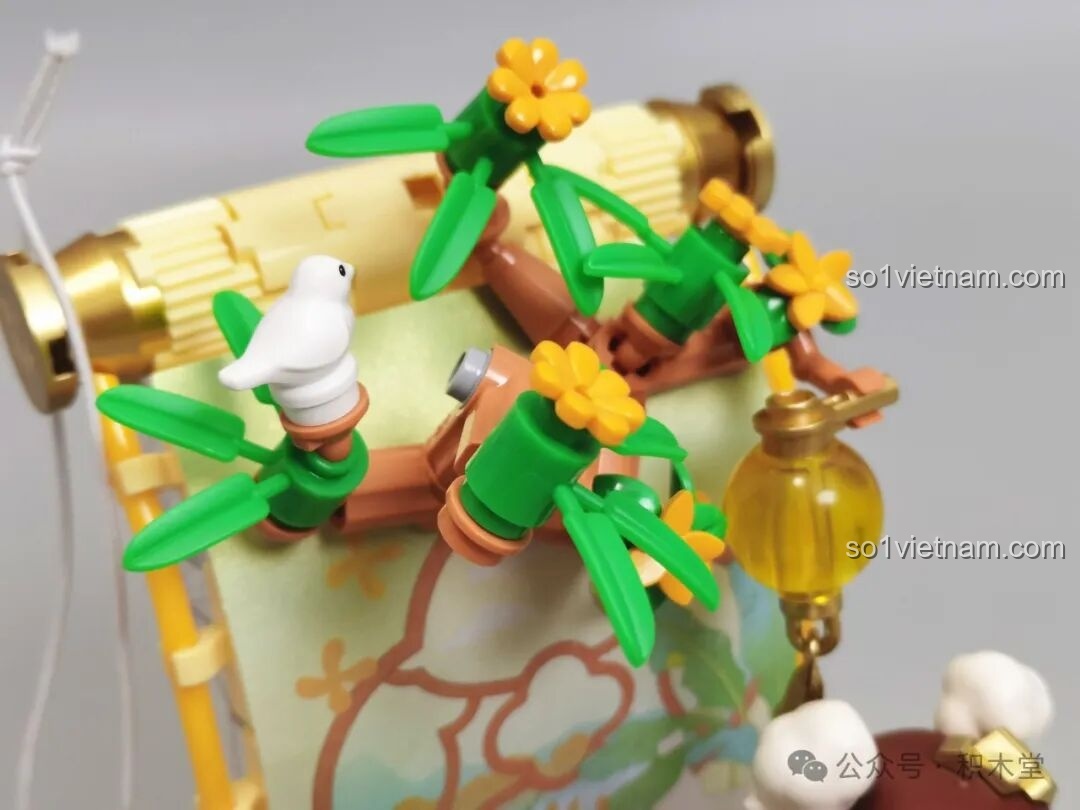 Cận cảnh cành cây với hoa vàng và chú chim trắng nhỏ trong bộ TOP TOY Nanci mùa Thu.