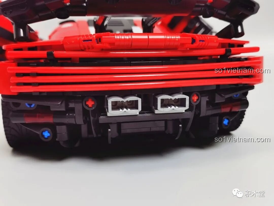 Cận cảnh phần đuôi xe với các ống mềm màu đỏ tạo thành dải đèn hậu và cụm ống xả kép.