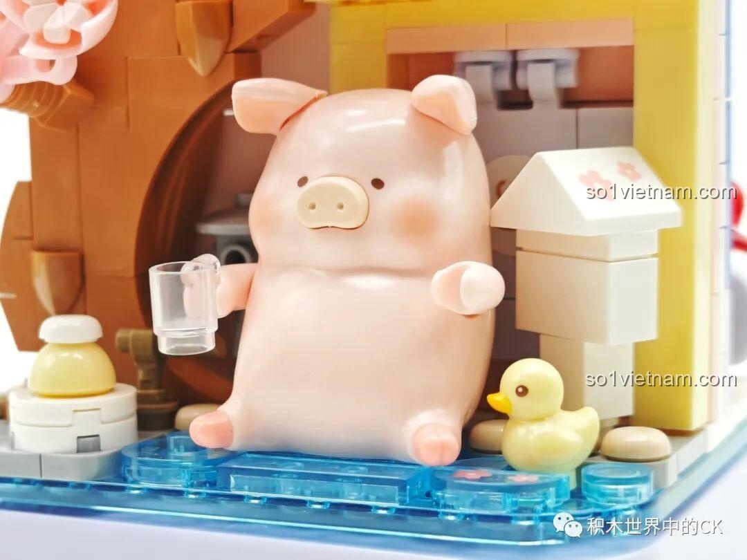 Cận cảnh Lợn LuLu cầm ly và chú vịt vàng nhỏ bên cạnh trong bộ đồ chơi trang trí Lợn LuLu.