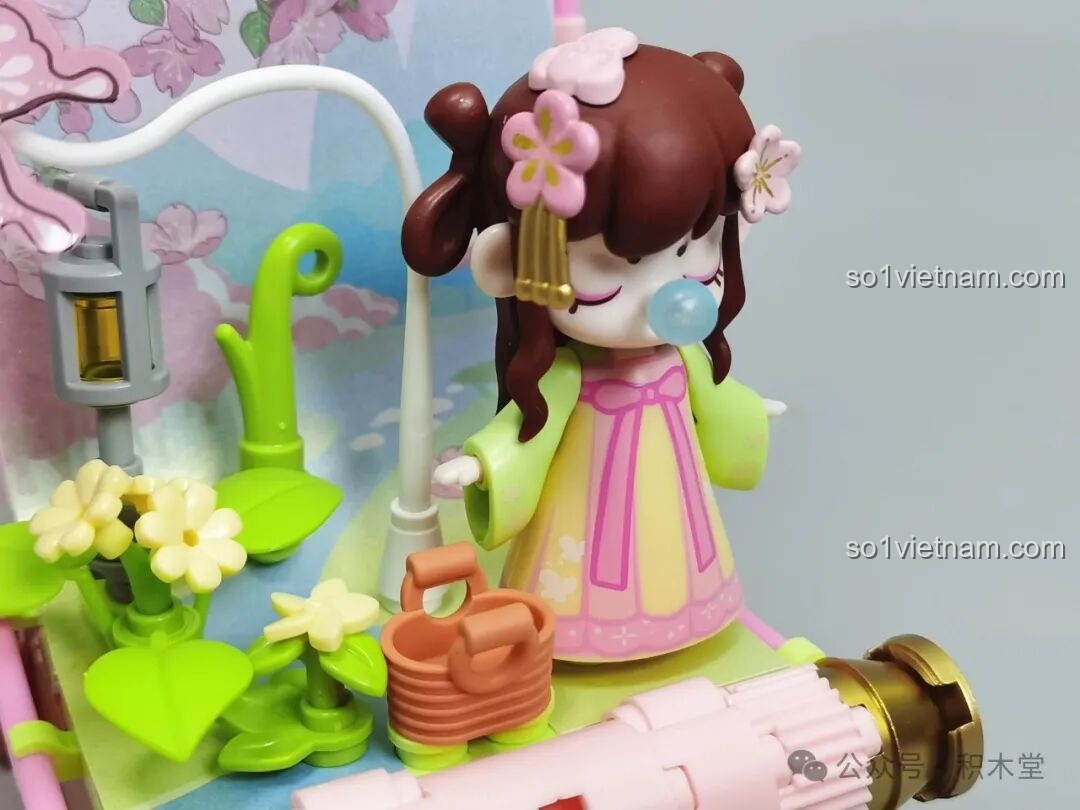 Cận cảnh minifigure Nanci mùa Xuân, đèn lồng và giỏ xách trong mô hình lắp ráp.