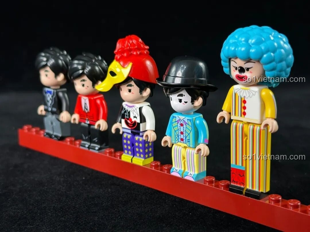 Ảnh chụp cận cảnh 5 minifigures của bộ Keeppley K21302 đứng trên một thanh gạch đỏ, khoe trang phục chi tiết.