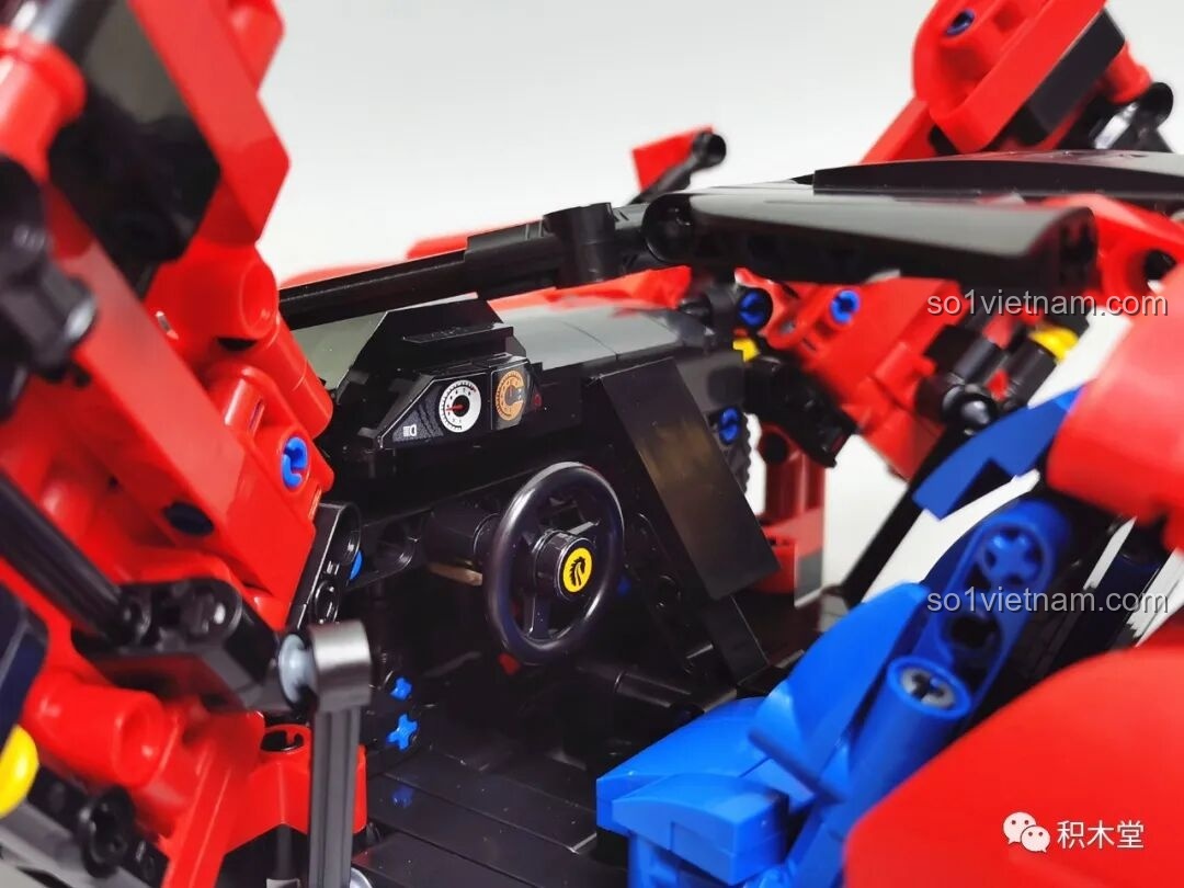 Cận cảnh không gian nội thất bên trong với vô lăng, bảng điều khiển có decal và ghế ngồi màu xanh.