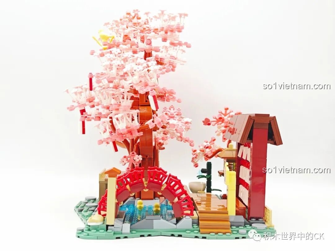 Cây cầu đỏ nổi bật trên nền xanh của hồ nước và màu hồng của hoa anh đào trong bộ Keeppley K20901.