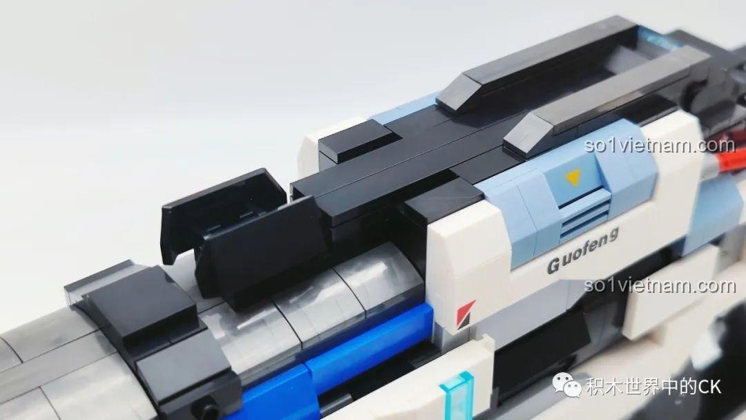 Cận cảnh cơ chế lên đạn hoặc khóa an toàn trên thân súng JIESTAR 58023, với sticker chữ 'Guofeng'.