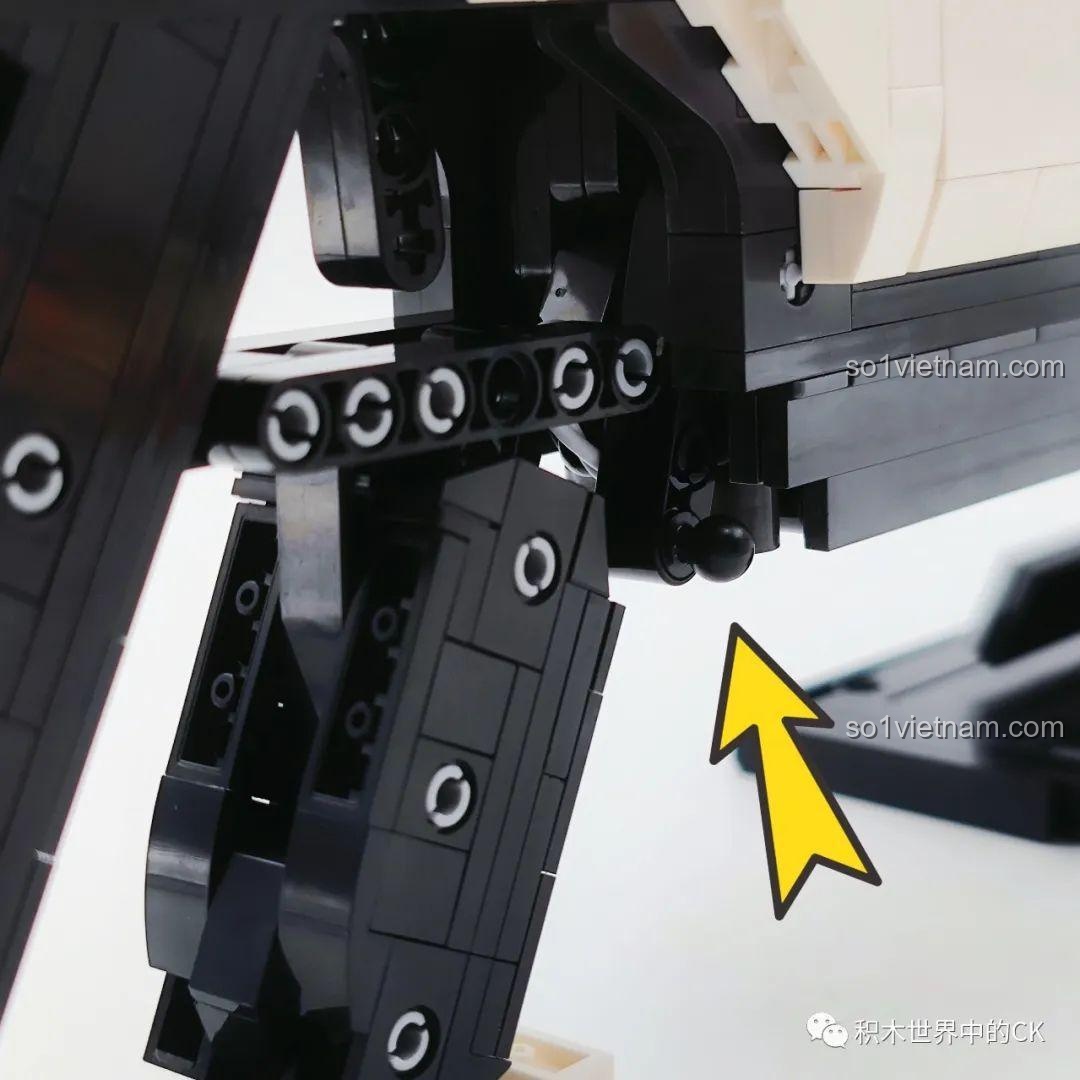 Cận cảnh chi tiết cò súng của mô hình JIESTAR 58023, được chỉ dẫn bằng một mũi tên màu vàng.