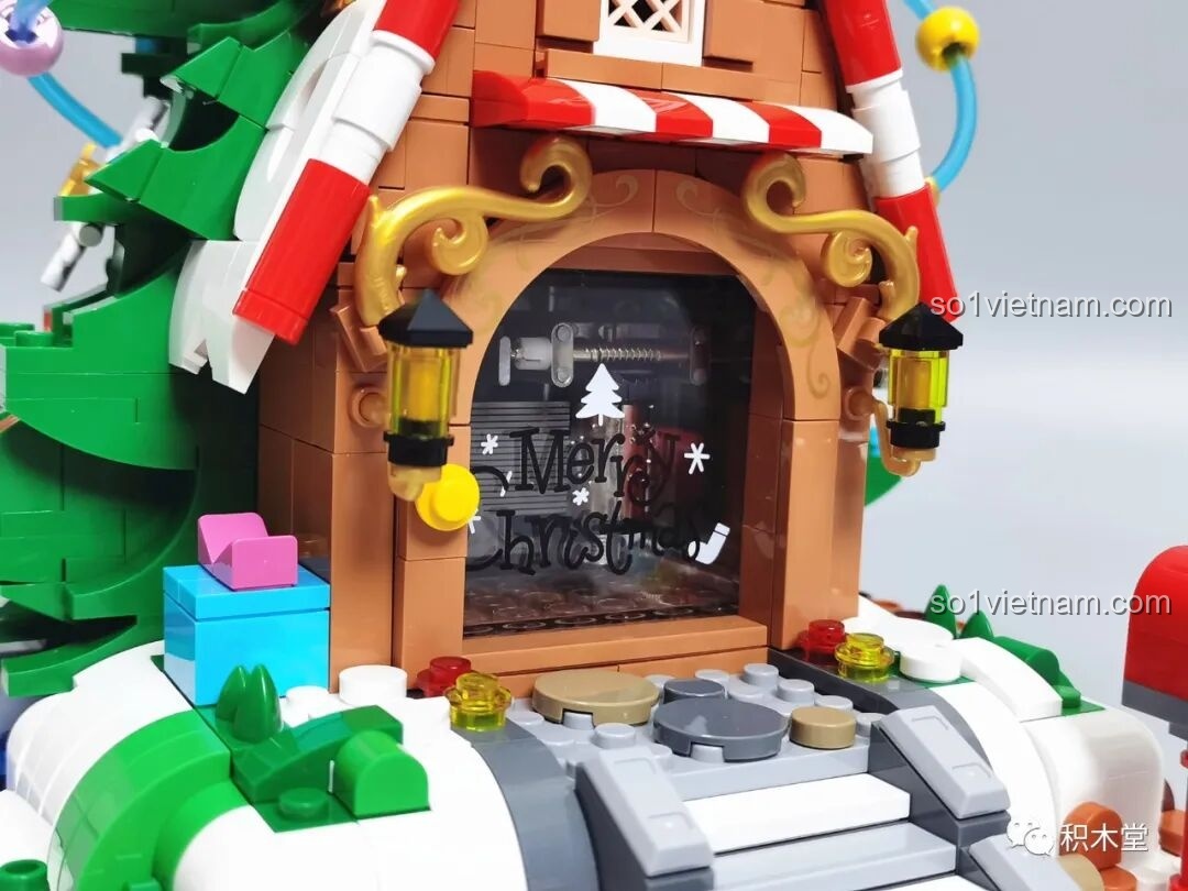 Cửa ra vào của ngôi nhà cây JAKI JK5128 với tấm kính trong in chữ 'Merry Christmas'.