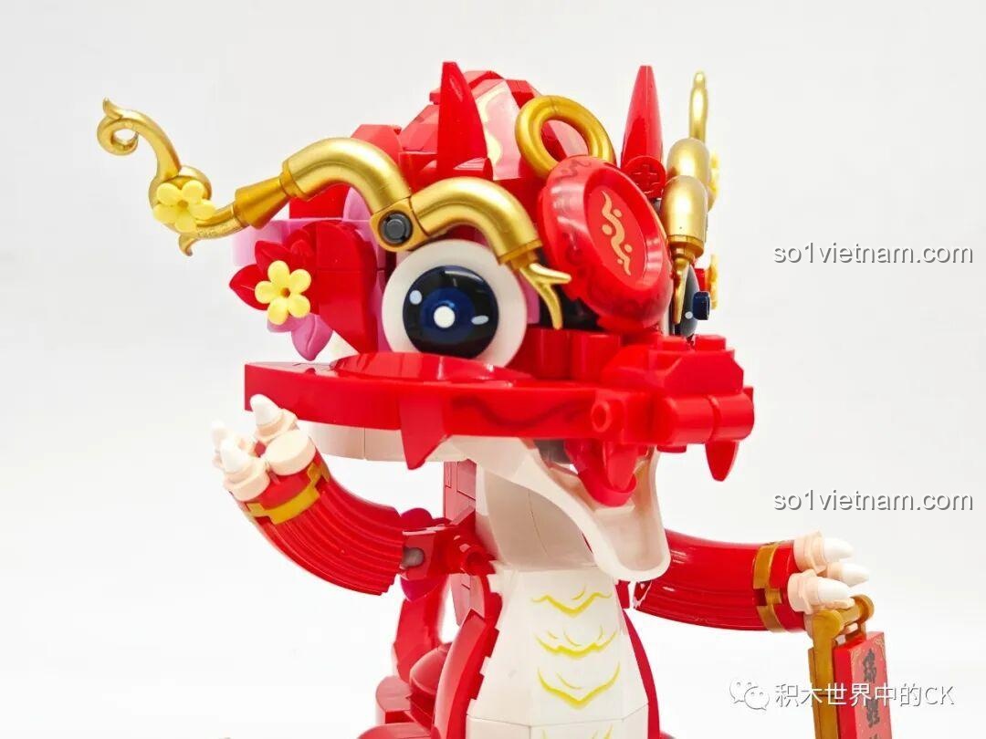 Cận cảnh phần đầu của chú rồng đỏ với đôi mắt to tròn và các chi tiết mạ vàng.