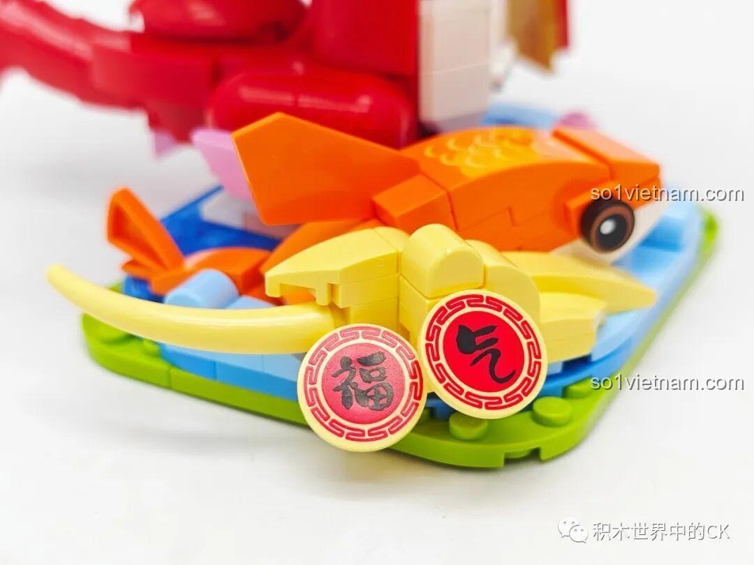 Cận cảnh phần đế nước với các chi tiết trang trí như đồng xu may mắn và hoa sen.