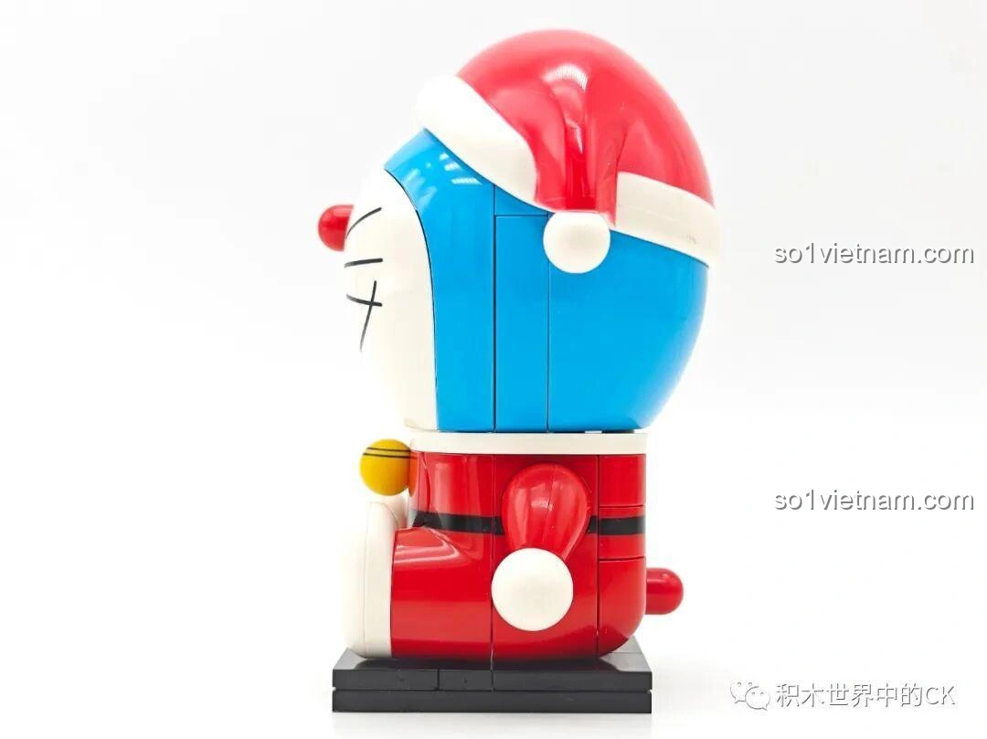 Góc nhìn bên trái của Doraemon Giáng Sinh K20414, thể hiện chi tiết mũ Noel và phần thân đỏ, cho thấy độ hoàn thiện của bộ lắp ghép Doraemon dáng tròn.