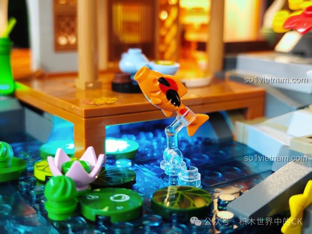 Chi tiết hồ nước của mô hình Lumibricks L9075 với hoa súng và cá Koi được chiếu sáng bởi đèn LED xanh dương.