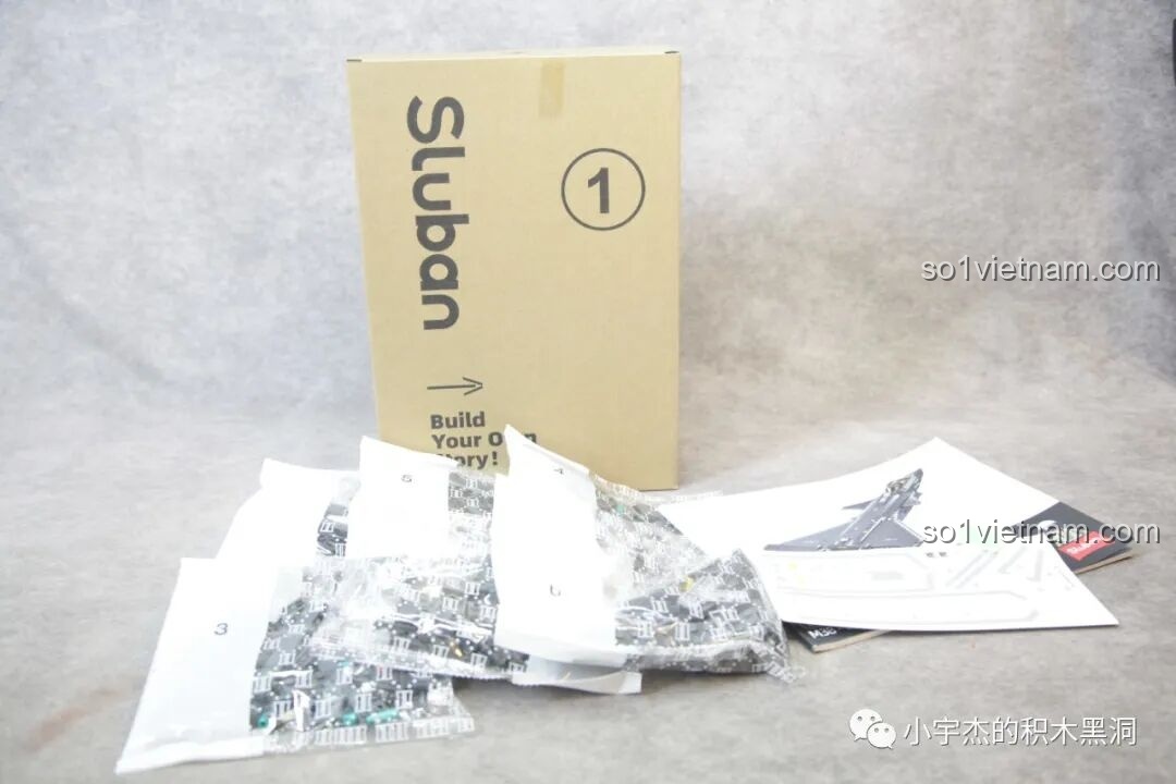 Nội dung hộp số 1 của bộ lắp ghép Sluban J-20 M38-B1187 Tiêm Kích Tàng Hình, bao gồm sách hướng dẫn, decal và các túi chi tiết được đánh số.