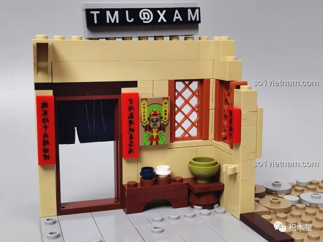 Các chi tiết in hình thần giữ cửa và câu đối trên các mảnh ghép của bộ đồ chơi mô hình.