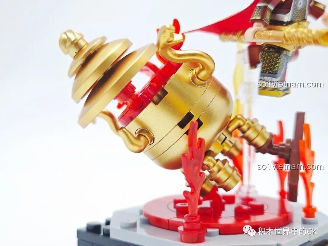 Cận cảnh chi tiết lò Bát Quái bằng nhựa mạ vàng, với các mảnh ghép lửa đỏ bên trong, từ bộ lắp ghép Chaoqiqu.