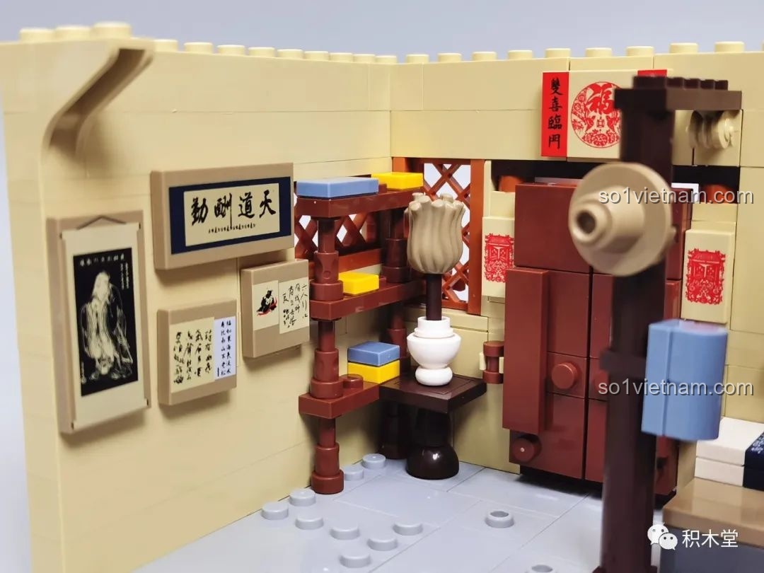 Chi tiết nội thất bên trong một phòng ngủ với tranh chữ, kệ sách và đèn.