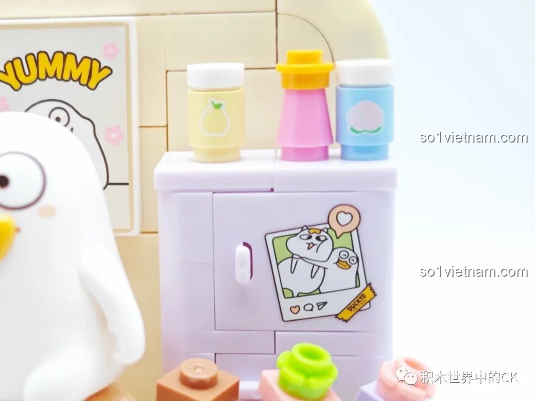 Chi tiết tấm poster Yummy với hình vẽ Vịt Liu đang ăn và các chai lọ trang trí trên kệ.