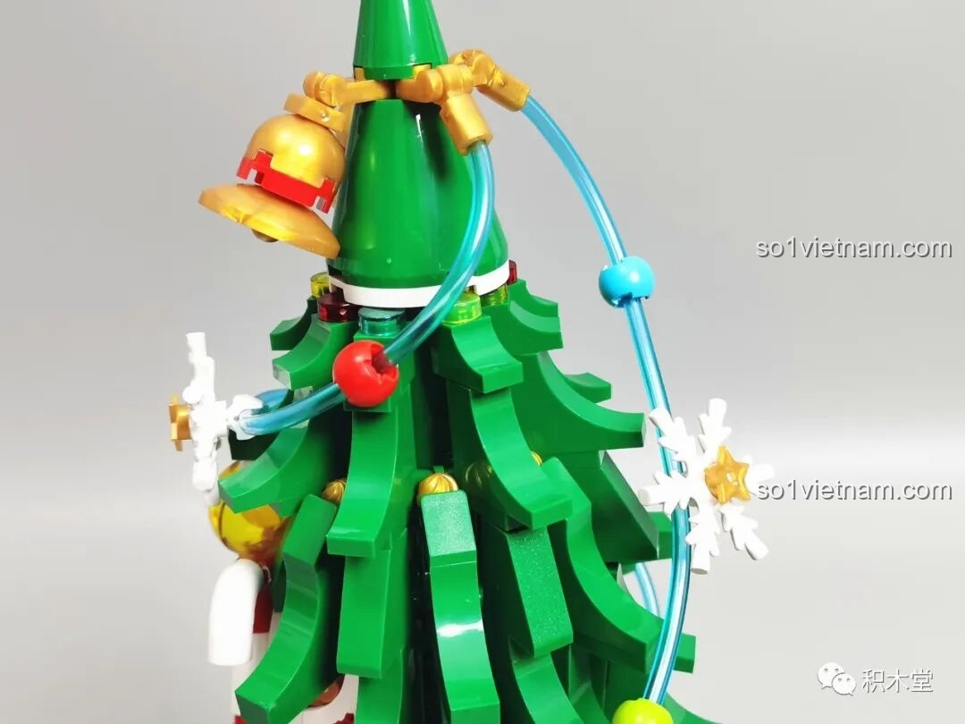 Chi tiết tán lá cây thông được trang trí với dây đèn và bông tuyết trong bộ JAKI JK5128.