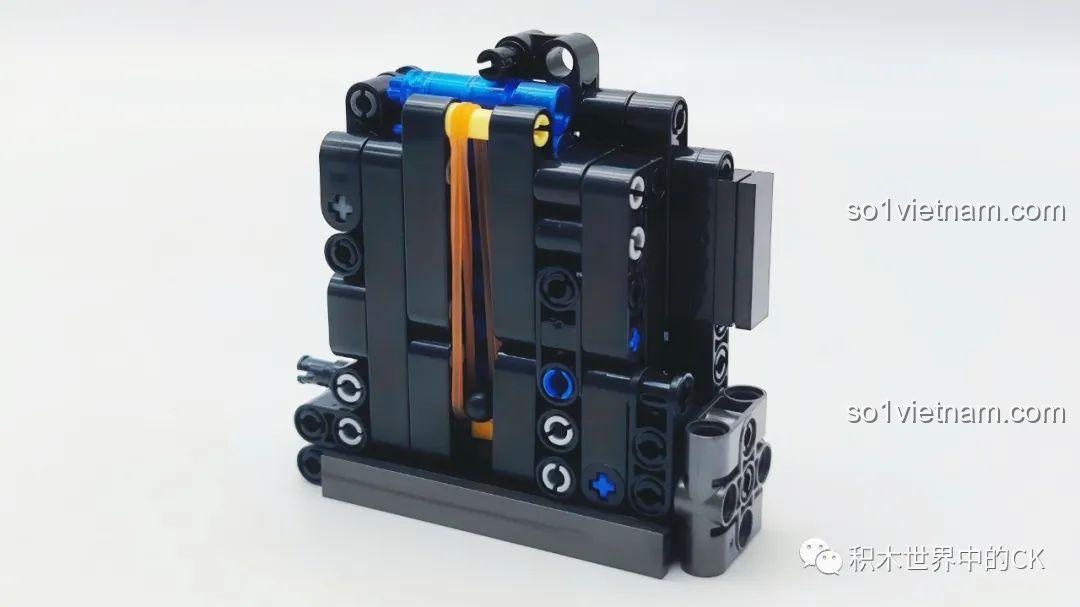 Cơ chế hoạt động bên trong băng đạn của súng JIESTAR 58023, sử dụng dây chun màu vàng để tạo lực đẩy.