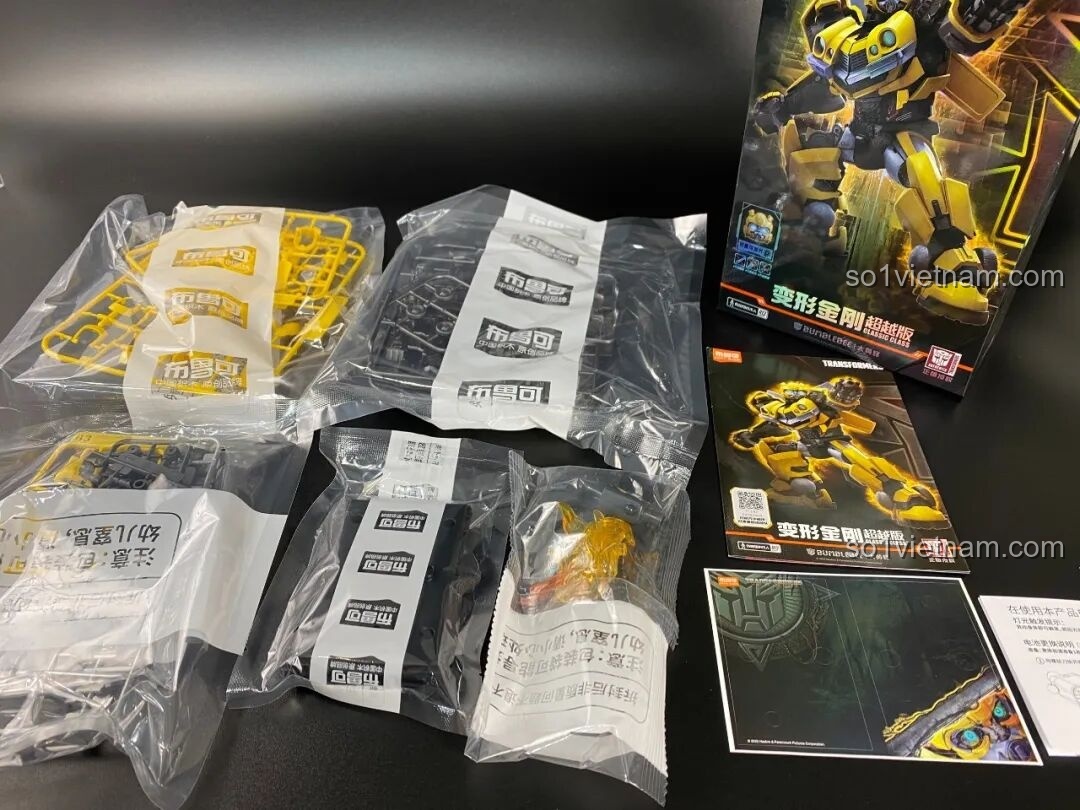 Bên trong hộp đồ chơi lắp ráp Blokees Bumblebee, với các vỉ nhựa và sách hướng dẫn.