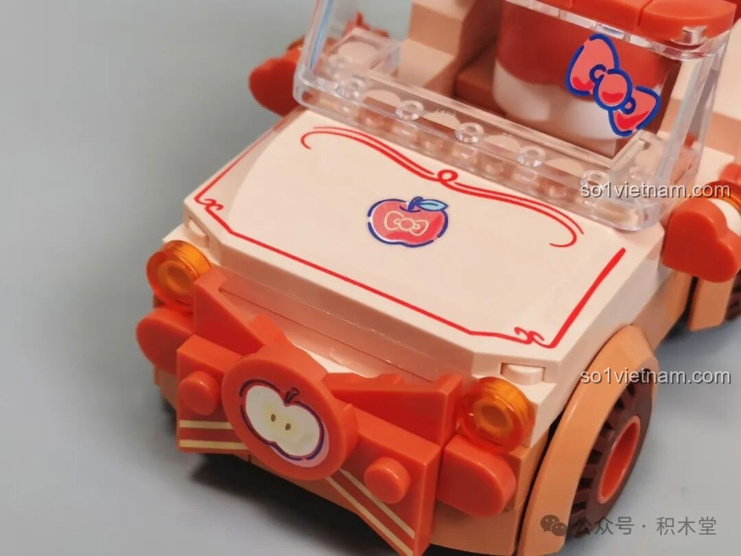 Chi tiết đầu xe mui trần Hello Kitty TC1724 với hình in quả táo và nơ.