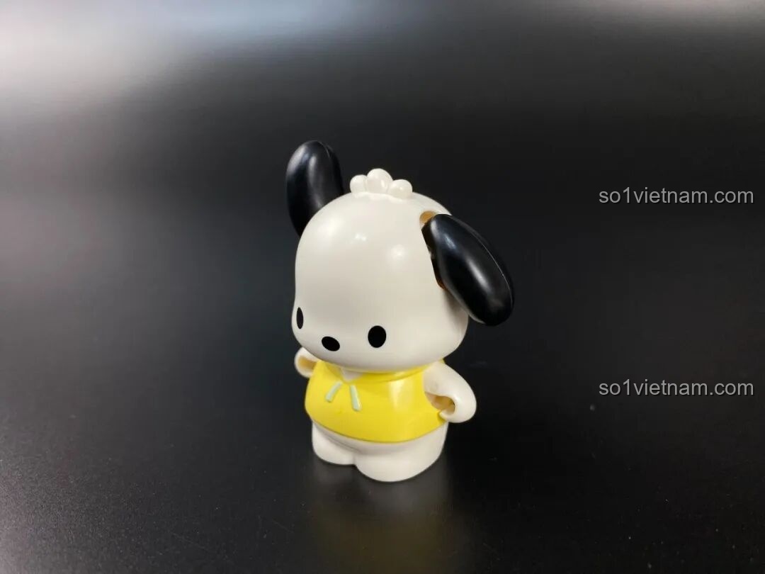 Cận cảnh figure Chú chó trắng tai đen Pochacco cho bé từ 12 tuổi đi kèm trong bộ K20820, mặc áo vàng.