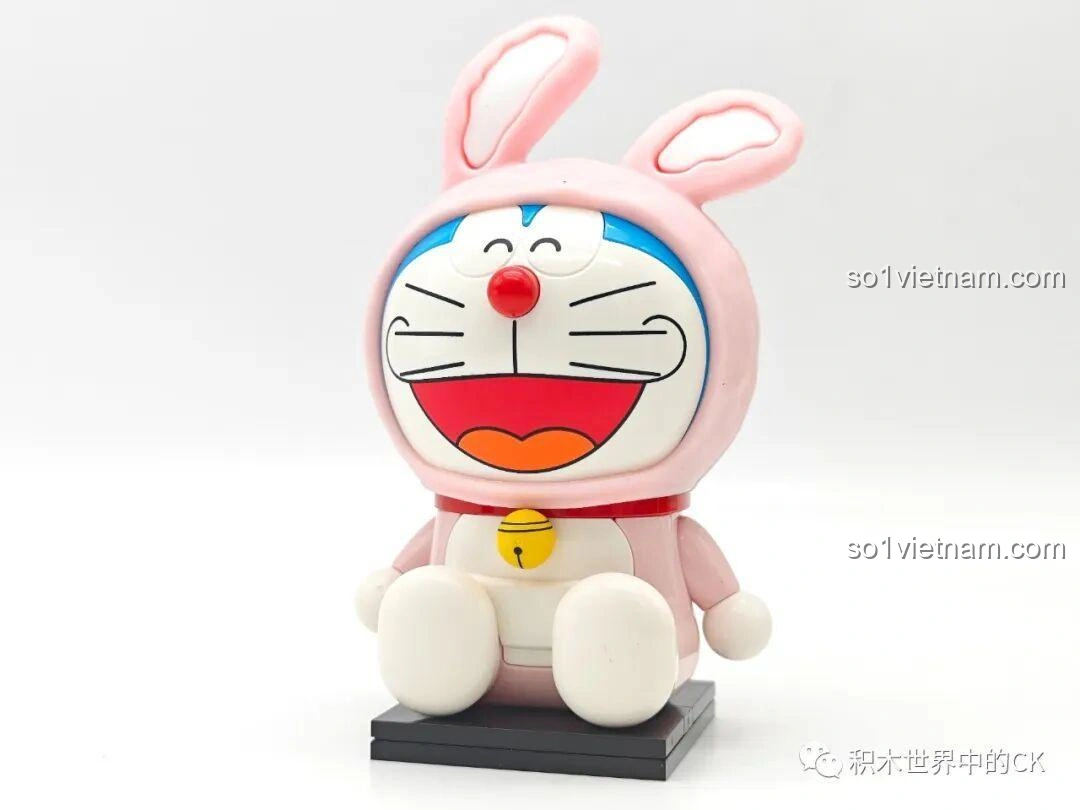 Mô hình Doraemon Thỏ Hồng K20415 đã hoàn thành, ngồi trên đế đen, với đôi tai thỏ và trang phục hồng, một figure Keeppley đáng yêu cho bé gái.