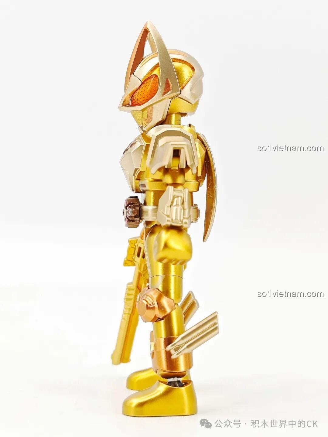 Góc nhìn nghiêng của figure Kamen Rider Geats phiên bản vàng, khoe chi tiết khẩu súng và các bộ phận giáp chân.