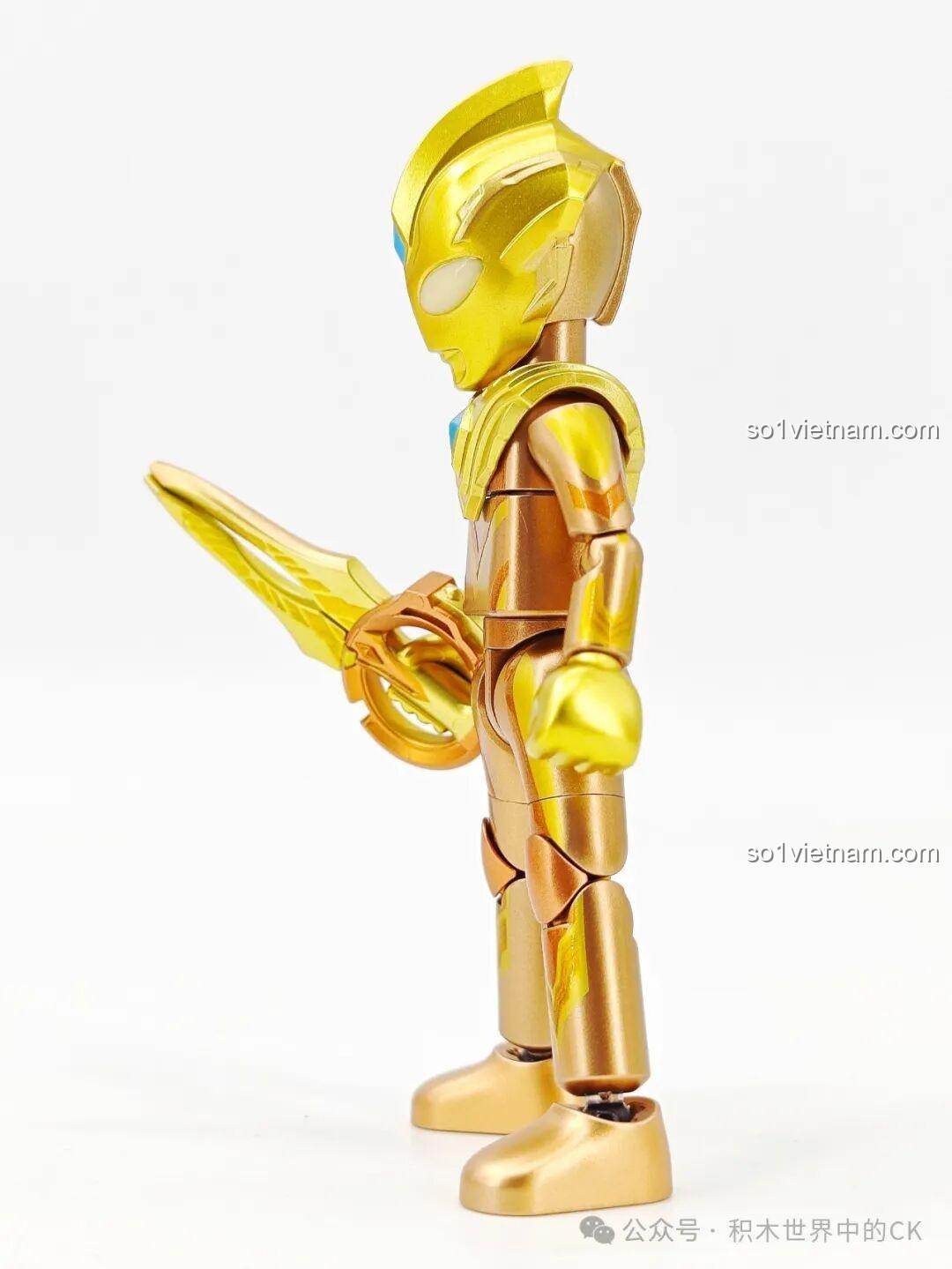 Góc nhìn nghiêng của figure Ultraman Trigger phiên bản vàng, thể hiện các đường nét trên bộ giáp và vũ khí Circle Arms.