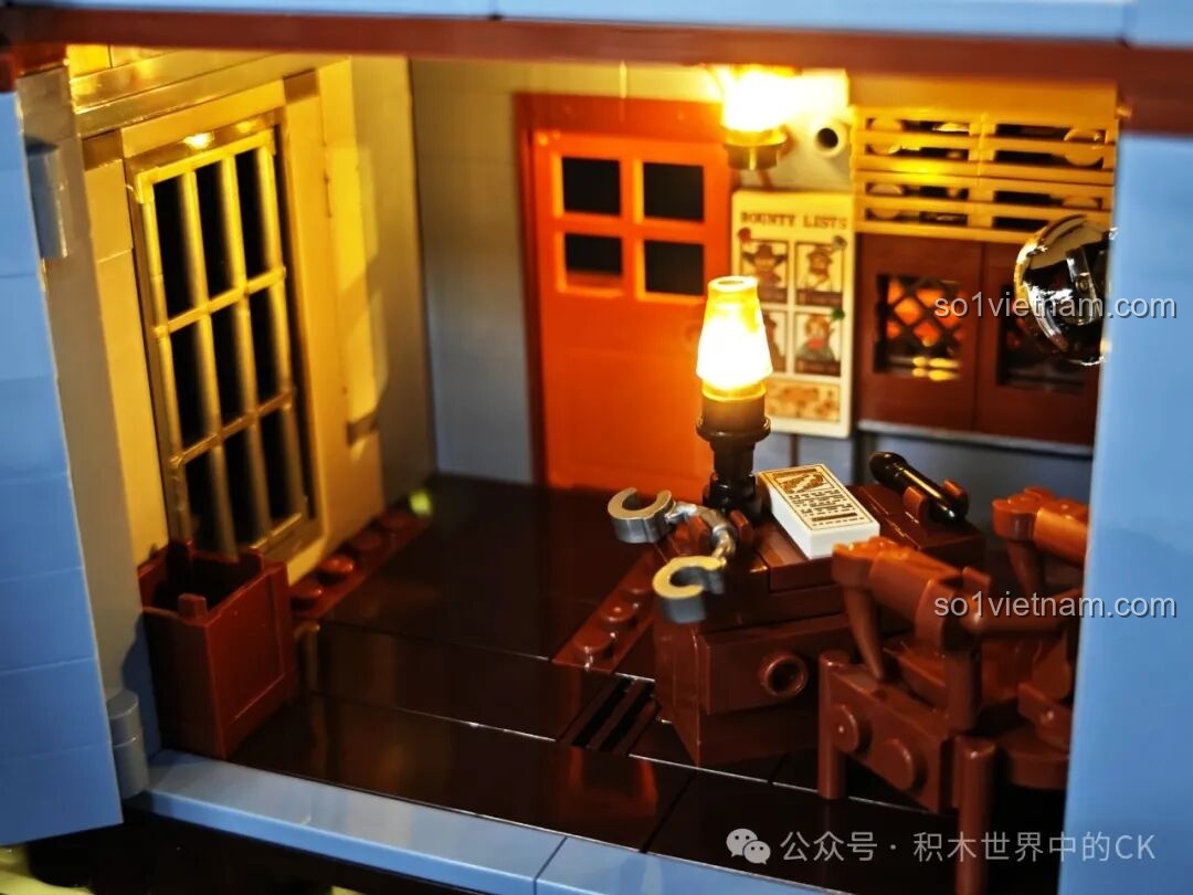 Nội thất tầng trệt của mô hình FunWhole F9026 Văn phòng Cảnh sát trưởng Miền Tây, bao gồm phòng giam và bàn làm việc.