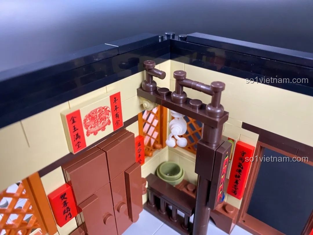 Giá treo đồ trong bếp với các chi tiết trang trí và câu đối đỏ.