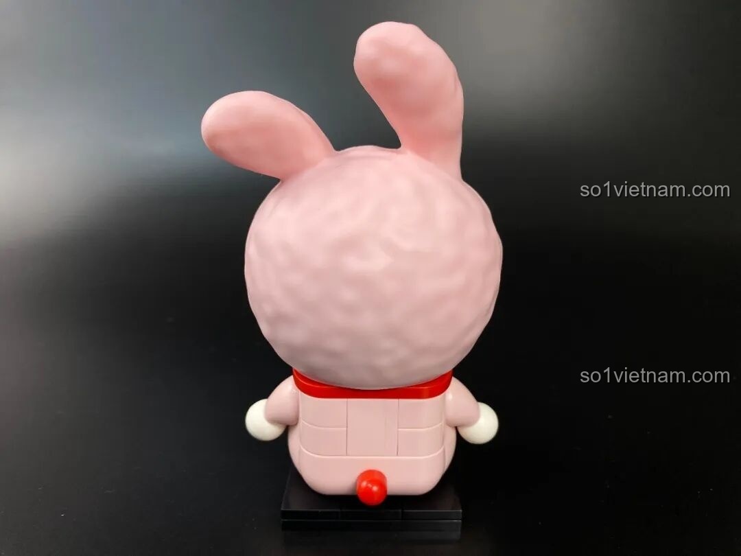 Góc nhìn bên phải của mô hình Doraemon thỏ hồng, cho thấy chi tiết mũ trùm đầu và thân hình tròn trịa.