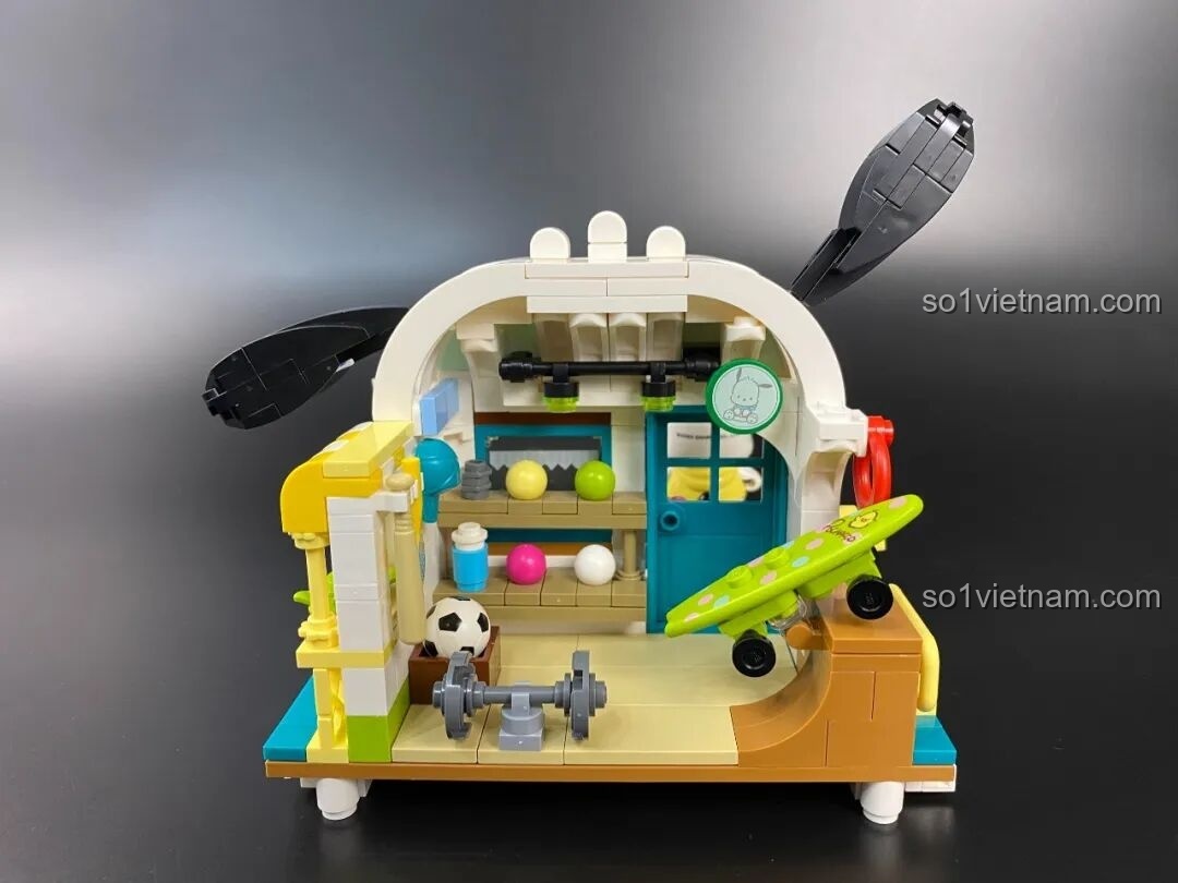 Góc nhìn bên trái của mô hình nhà thi đấu Pochacco, cho thấy các chi tiết trang trí như phao cứu sinh và ván trượt.