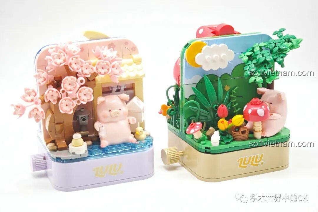 Hai bộ mô hình Sembo Lợn LuLu Nhà Nấm và Hoa Anh Đào đặt cạnh nhau, hiển thị mặt B của cả hai.