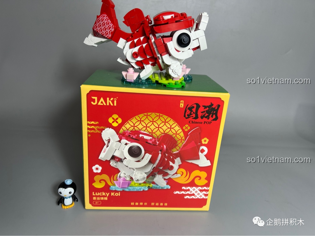 Mô hình Cá Chép Vận May JAKI được trưng bày trên chính hộp đựng của nó, một cách sáng tạo để khoe sản phẩm.