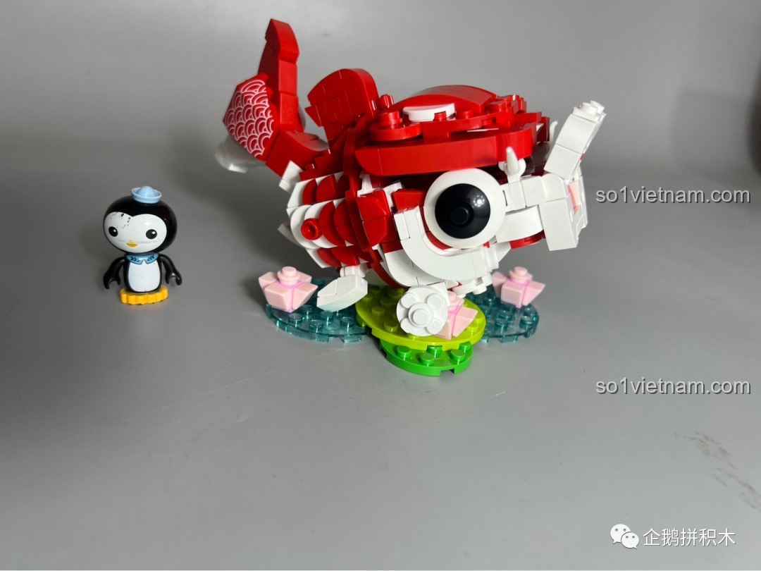 Mô hình Cá Chép Vận May JAKI hoàn thiện được đặt cạnh hộp sản phẩm, cho thấy sự tương đồng cao.