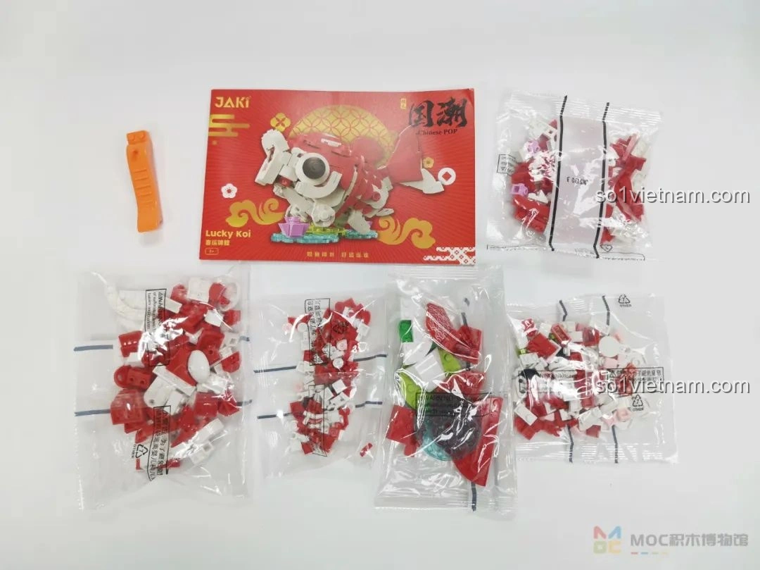Các túi mảnh ghép và sách hướng dẫn của bộ lắp ráp JAKI JK20236 Cá Chép May Mắn, sẵn sàng để tạo hình chú cá chép đỏ trắng.