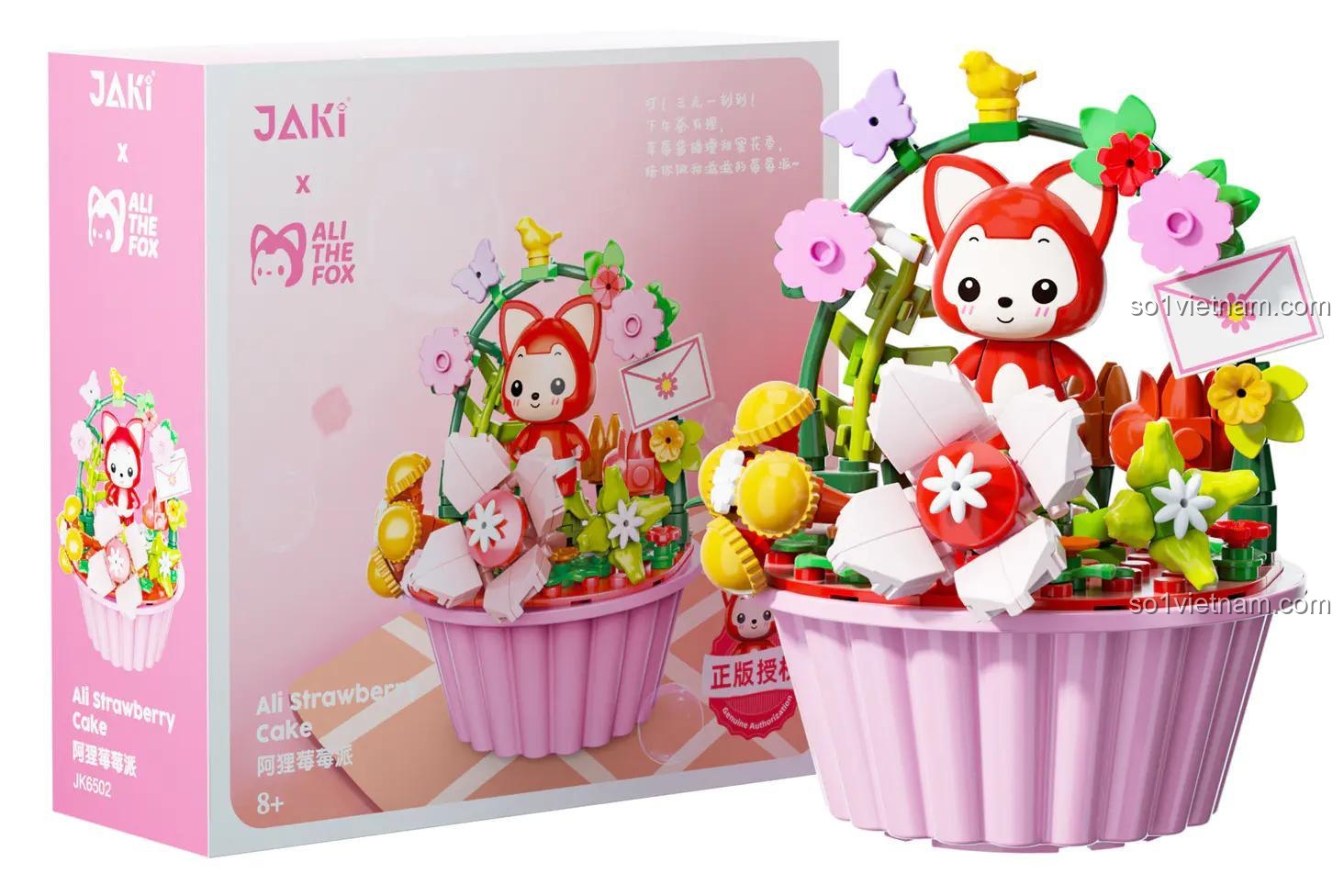 Hình ảnh hộp sản phẩm đồ chơi mô hình JAKI JK6502 Bánh Cupcake Dâu Tây Cáo Ali. Hộp màu hồng và trắng, có logo JAKI và Ali The Fox, phù hợp làm quà tặng cho con gái.