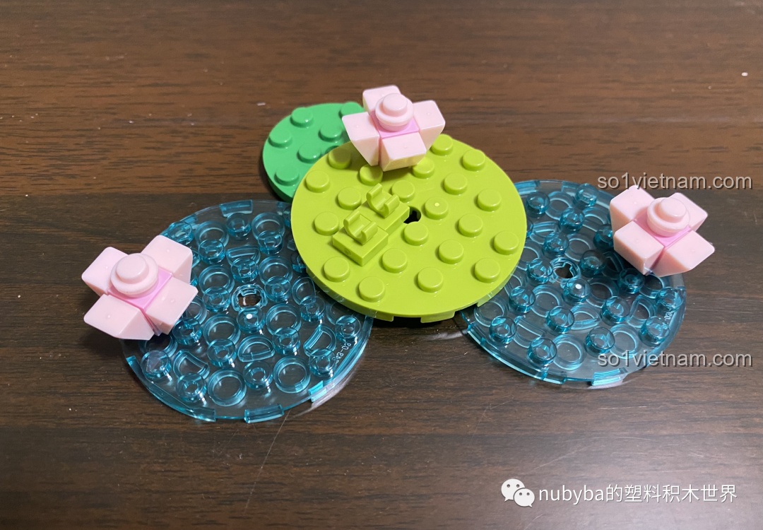 Quá trình lắp ráp phần đế của mô hình JAKI Lucky Koi, mô phỏng mặt nước với lá sen và hoa sen màu hồng.