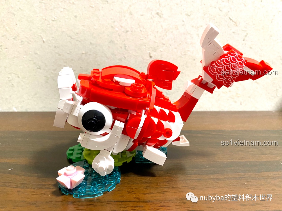 Mô hình JAKI Lucky Koi đã hoàn thành, chú cá chép đỏ trắng sống động đang quẫy đuôi trên mặt nước trong xanh.