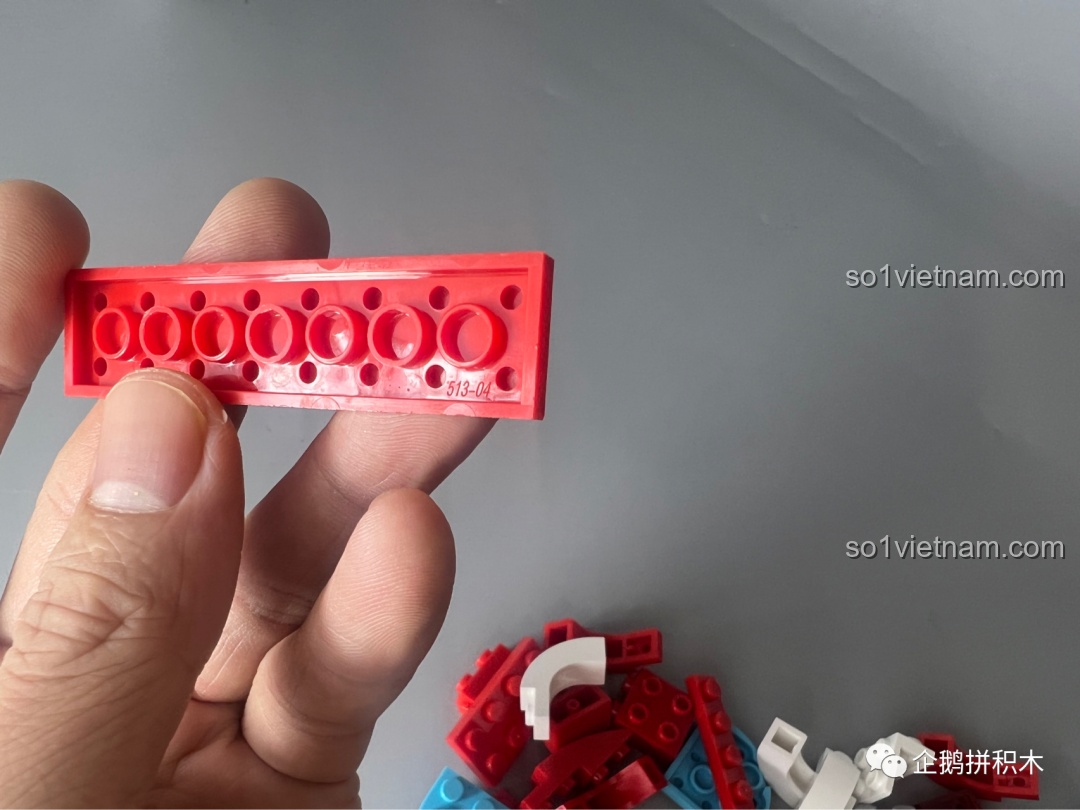 Một mảnh ghép dài màu đỏ của bộ lắp ghép JAKI Sư Tử Múa Lân, thể hiện độ hoàn thiện cao của sản phẩm.