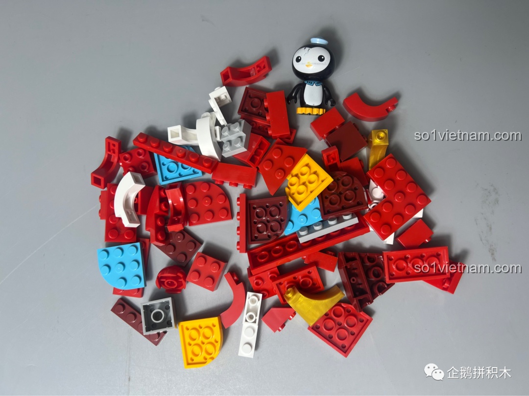 Các mảnh ghép của bộ lắp ráp JAKI Sư Tử Múa Lân được đổ ra, chủ yếu là màu đỏ, vàng, xanh và trắng.